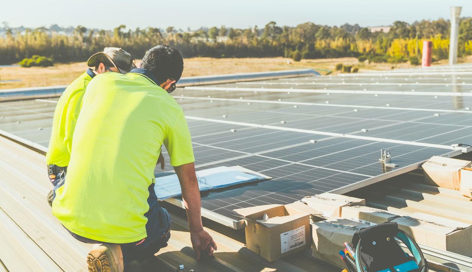 Technicians installing solar panels on a rooftop